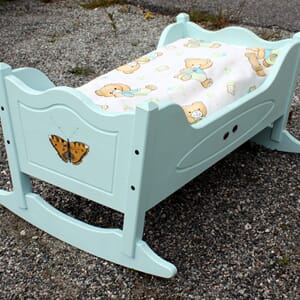 Dukkevugge med dekor og sengtøy